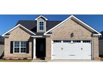 Brick house with a white garage door and landscaping at 190 Brunswick Dr, Nashville, NC 27856