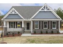 New construction home with gray siding, stone accents, and a front porch at 115 Ironwood Blvd # 51, Youngsville, NC 27596