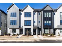 Modern townhomes with a gray, black, and white color scheme, enhanced by large windows and professional landscaping at 1156 Cottonsprings Dr, Wendell, NC 27591