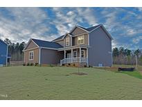 Beautiful two-story home featuring a charming front porch and manicured lawn at 4466 Debnam Rd, Zebulon, NC 27597