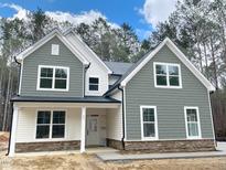Charming two-story home featuring stone accents, gray siding, white trim, and large windows at 83 Artic Circle, Garner, NC 27529