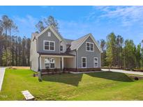 Charming two-story home featuring stone accents, gray siding, white trim, and large windows at 83 Artic Circle, Garner, NC 27529