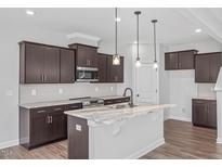 Modern kitchen boasts dark cabinetry, granite countertops, and stainless steel appliances at 176 Van Winkle St, Lillington, NC 27546