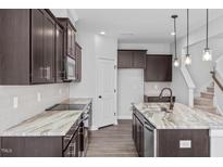 Modern kitchen with dark cabinets, granite countertops, and stainless steel appliances at 176 Van Winkle St, Lillington, NC 27546