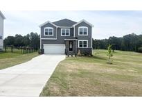 Charming two-story home boasts a modern exterior with gray siding and a well-manicured lawn at 592 Barbour Farm Ln, Four Oaks, NC 27524