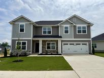 Beautiful two-story home with gray siding, stone accents, and a well-manicured front lawn at 122 Southern Estates Dr, Sanford, NC 27330