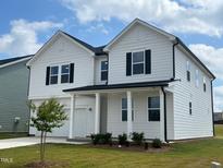 Two-story white house with a covered porch and landscaped yard at 260 Chestnut Oak Ln, Lillington, NC 27546