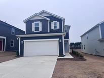 Two-story house with gray siding, white garage door, and landscaping at 2724 Princess Tree Dr, Raleigh, NC 27616