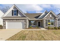 Beautiful single Gathering home featuring stone accents, gray siding, two-car garage and manicured front lawn at 52 Gander Dr, Benson, NC 27504