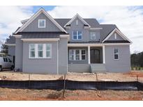 Newly constructed two-story home featuring gray brick, a covered porch, and a dark roof at 2909 Frances Marie Ln, Raleigh, NC 27603