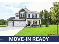 Move-in ready two-story home boasts a charming exterior, two-car garage, and lush lawn at 196 Abingdon Farms Dr, Selma, NC 27576