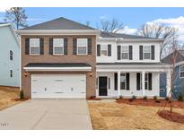 Charming two-story home featuring brick and siding, a two-car garage, and well-manicured front yard at 232 Berry Mill Ln # 201, Raleigh, NC 27603