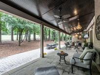 Expansive covered patio featuring a fan, chandelier, outside dining and kitchen perfect for entertaining and relaxing at 106 Dundee Ct, Cary, NC 27511