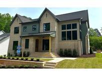 New construction home boasts a brick and siding exterior with a covered porch and manicured lawn at 1000 Marilyn Dr, Raleigh, NC 27607