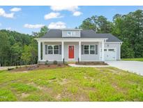 Charming single-story home featuring a red front door, gray siding, and well-manicured lawn at 148 Harmony Trl, Broadway, NC 27505