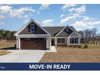 Charming single-Gathering home featuring a two-car garage and a well-manicured front yard at 48 Tanseyleaf Dr, Smithfield, NC 27577