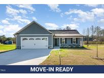 Charming single-story home with a two-car garage, inviting front porch, and landscaped front yard at 104 Burnello Ct, Princeton, NC 27569