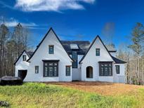Stunning two-story home with a white brick exterior and a metal roof at 7621 Falls Creek Ln, Raleigh, NC 27614