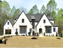 Stunning new construction home featuring a white brick facade, dark window trim, and lush landscaping at 7621 Falls Creek Ln, Raleigh, NC 27614
