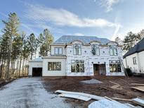 Two-story home under construction with large windows, gravel driveway, and frame showing at 2728 Trifle Ln, Wake Forest, NC 27587