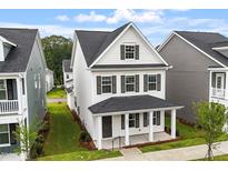 Charming two-story home features a covered front porch, black shutters, and a well-manicured front lawn at 9249 Kitchin Farms Way # 432, Wake Forest, NC 27587