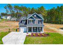Charming two-story home with gray siding, white trim, and a well-manicured front lawn at 457 Duncan Creek Rd # 141, Lillington, NC 27546