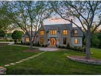 Stunning stone and shingle home boasts mature trees, manicured lawn, and inviting stone walkway at 1641 Legacy Ridge Ln, Wake Forest, NC 27587