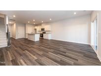 Open-concept living room with modern flooring, kitchen, and access to outdoor space at 569 Marthas Vw Way, Wake Forest, NC 27587