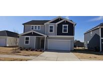 Two-story home with gray and navy siding, a white garage door, and landscaping at 115 Shooting Star Trl, Youngsville, NC 27596