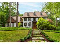 Charming two-story white brick home with manicured landscaping and a stone pathway leading to the entrance at 1800 Bay Meadow Ct, Raleigh, NC 27615