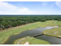 Aerial view of a golf course community with a pond and houses at 90 Brandon Dr, Lillington, NC 27546