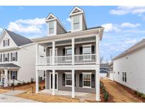 Charming two-story home with a covered porch, perfect for enjoying the outdoors at 9301 Kitchin Farms Way # 433, Wake Forest, NC 27587