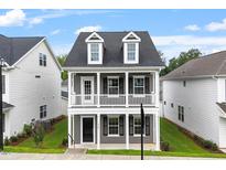 Charming two-story home with a welcoming front porch, dormer windows and manicured lawn at 9301 Kitchin Farms Way # 433, Wake Forest, NC 27587