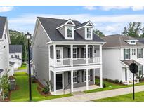 Charming two-story home with a gray exterior, a welcoming porch, and a well-maintained lawn at 9301 Kitchin Farms Way # 433, Wake Forest, NC 27587