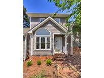 Charming home with gray siding, white trim, brick accents, and beautiful architectural windows for great curb appeal at 1432 Quarter Pt, Raleigh, NC 27615