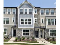 Charming townhome featuring stone accents, a well-manicured lawn, and a welcoming front entrance at 3006 Freewinds Way # 41, Cary, NC 27519