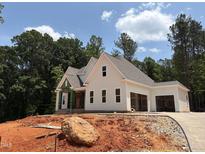 Charming new construction home featuring a two-car garage, lush trees, and a paved driveway under a blue sky at 111 Gaines Trail, Pittsboro, NC 27312