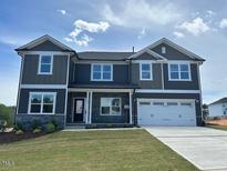 Inviting two-story home featuring a two-car garage and a well-manicured front lawn at 136 Newport Lndg, Garner, NC 27529