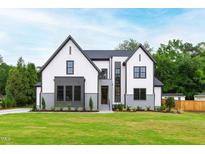 Beautifully landscaped two-story home with a well-manicured lawn and gray and white exterior at 5812 Shawood Dr, Raleigh, NC 27609