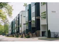 Modern townhomes with a contemporary design and inviting entrances with stairs and landscaping along the street at 600 Rocky Knob Ct, Raleigh, NC 27601