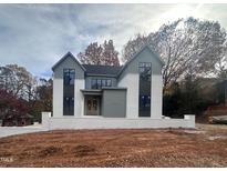 Striking two-story home featuring a modern white brick base and gray gabled roof at 5208 Knollwood Rd, Raleigh, NC 27609