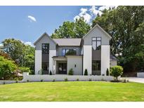 Beautiful two-story home featuring modern design elements and lush green lawn at 5208 Knollwood Rd, Raleigh, NC 27609