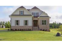 Beautiful new construction home featuring stone accents, a landscaped yard, and a welcoming front entrance at 55 Harvest View Way, Franklinton, NC 27525