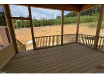 Unfinished wood deck with railings offers serene views of the natural landscape at 6052 Scalybark, Durham, NC 27712