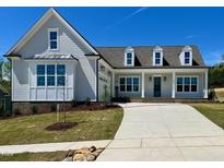 Inviting new construction home featuring a manicured lawn and a long concrete driveway at 6052 Scalybark Rd, Durham, NC 27712