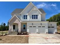 Beautiful two-story home with white siding, brick accents, and a three-car garage at 6048 Scalybark Rd, Durham, NC 27712