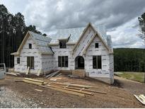 New home construction featuring large windows and archway on a wooded lot at 37 Green Turtle Ln, Pittsboro, NC 27312