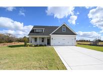 Charming single-Gathering home featuring a two-car garage and inviting front yard, set against a bright blue sky at 248 Johnson Ridge Way, Four Oaks, NC 27524