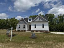 Charming two-story home with white and grey siding and a well-manicured lawn at 35 Uptown Rd, Zebulon, NC 27597