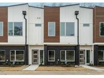Modern townhome exterior featuring a brick facade, wood and white siding, and contemporary design at 1533 Urban Trace Ln, Raleigh, NC 27608